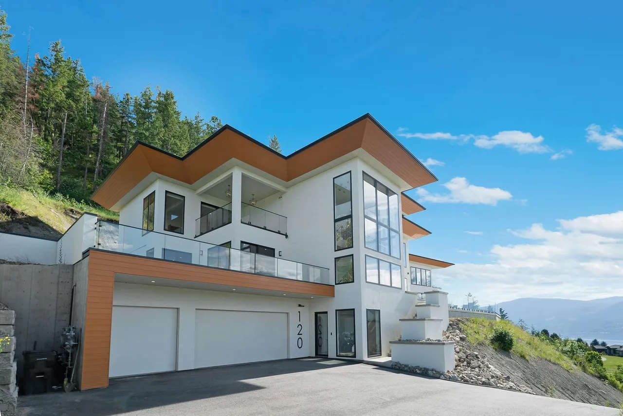 Sunset Boulevard from the driveway: white stucco, wood soffits and a double garage under the upper decks