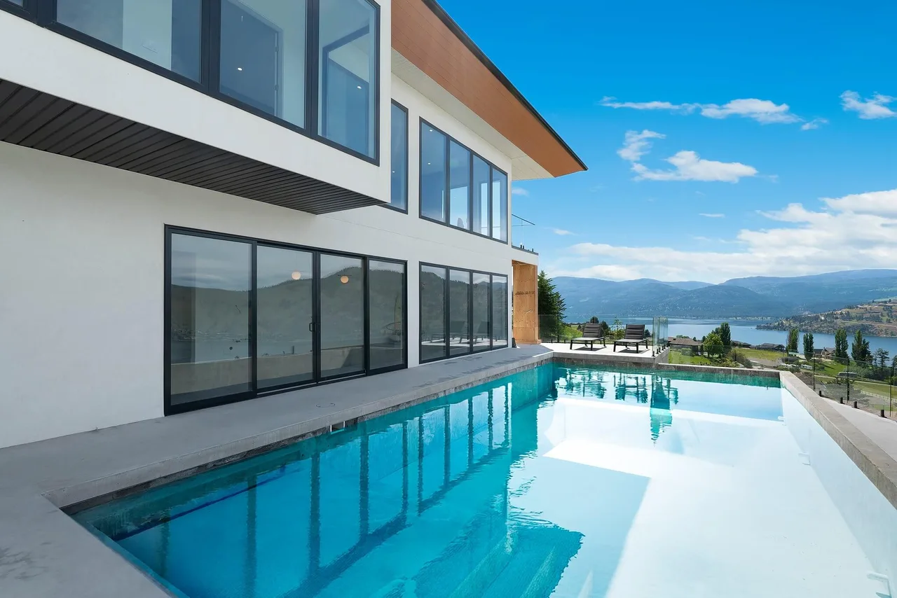 Sunset Boulevard’s infinity pool along the side of the home, with the lake and hills beyond