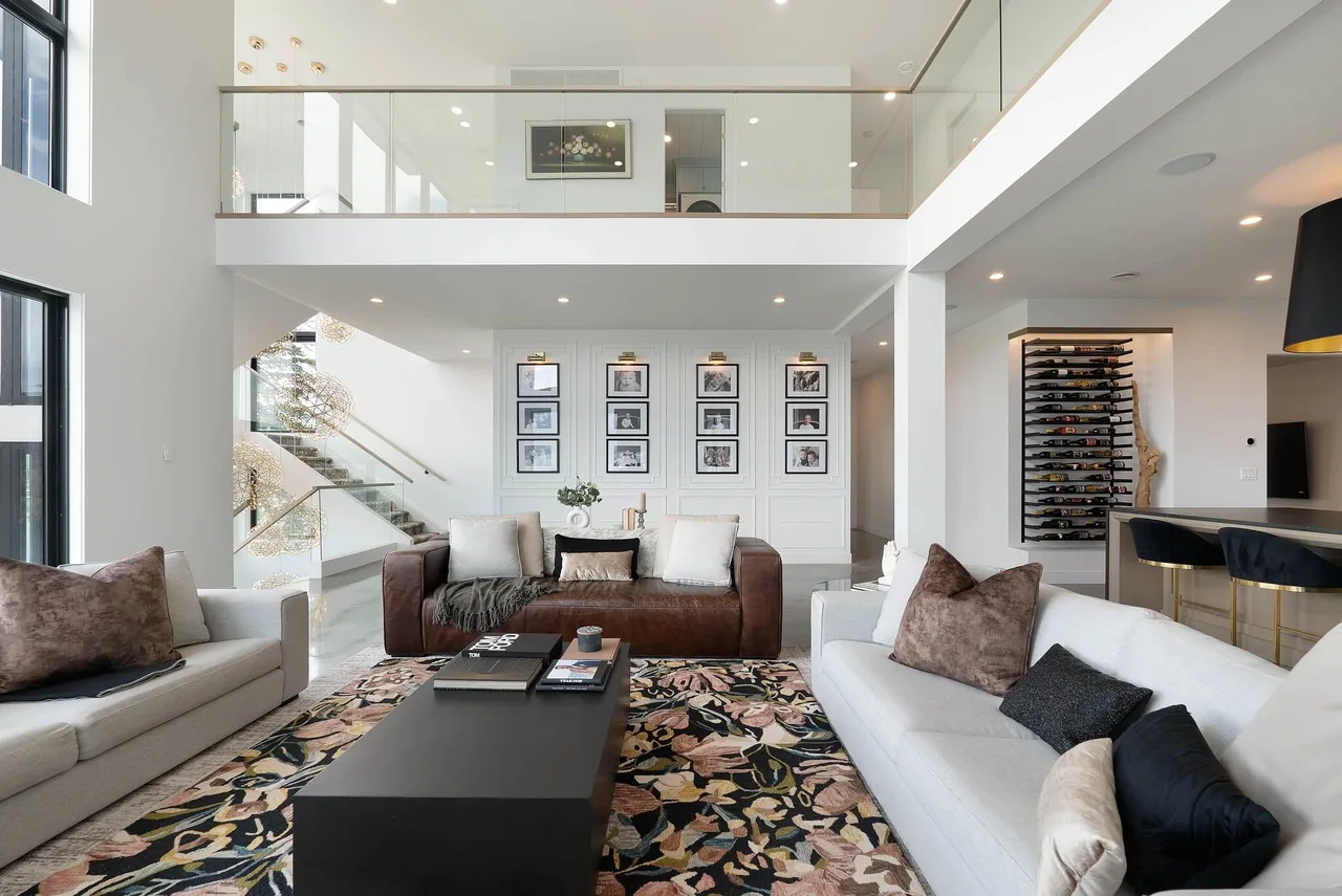 The double-height living room, with a gallery wall, a wine wall and an open landing above