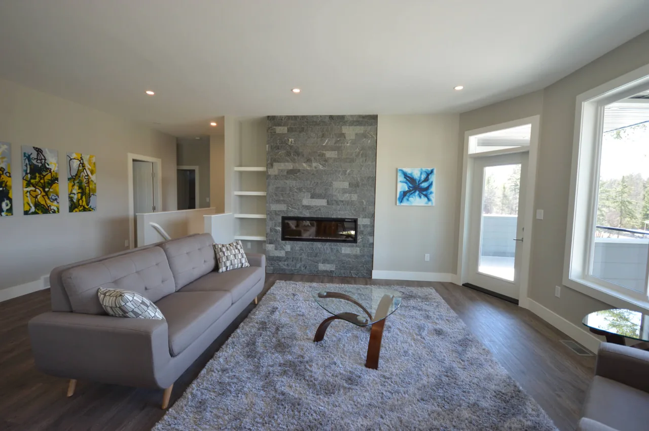 The living room’s floor-to-ceiling stone fireplace with an electric insert