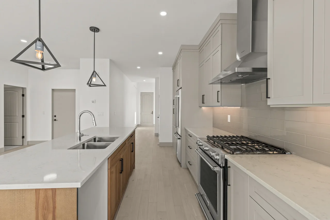 The galley side of the kitchen, with a gas range and a long quartz counter