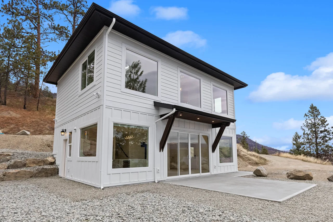The carriage house’s sliding glass doors and timber-bracketed entry roof