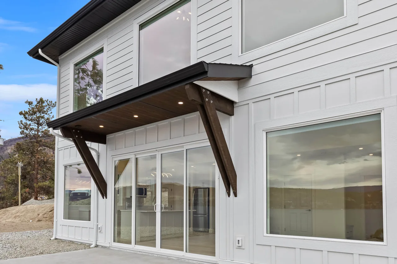The timber-bracketed canopy over the sliding doors onto the patio